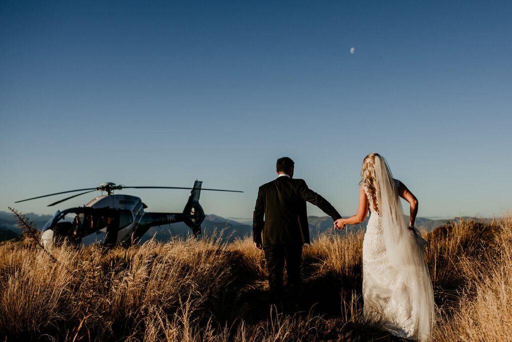 Back of the bride and groom heading back to the helicopter after their Mountain Elopement in Queenstown NZ