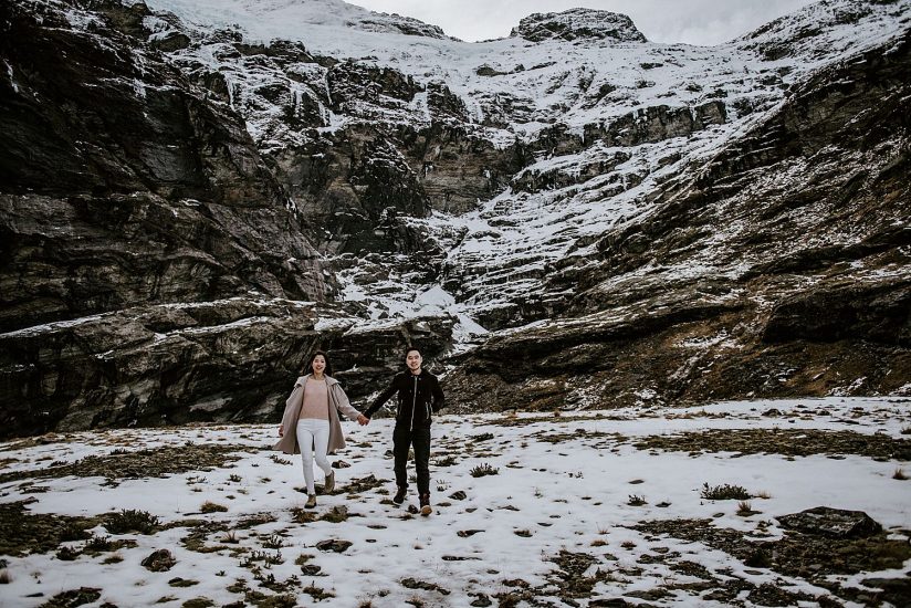 Couple in the snow holding hands on a photoshoot, Queenstown elopements 