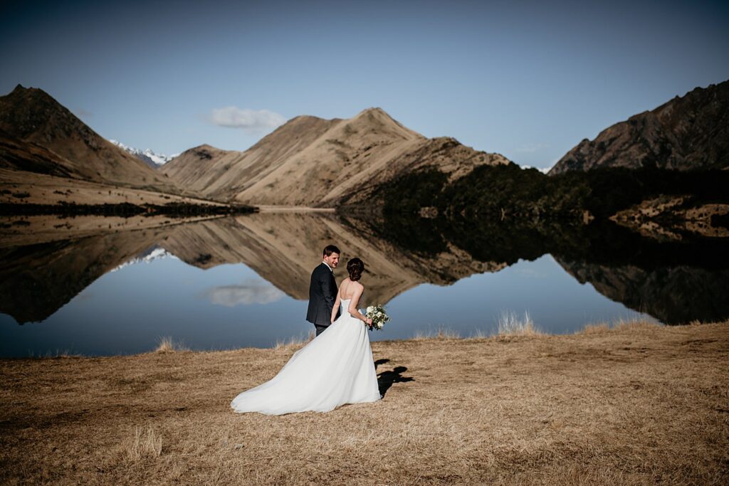 Couple getting married at Moke Lake with a mirror lake in the background